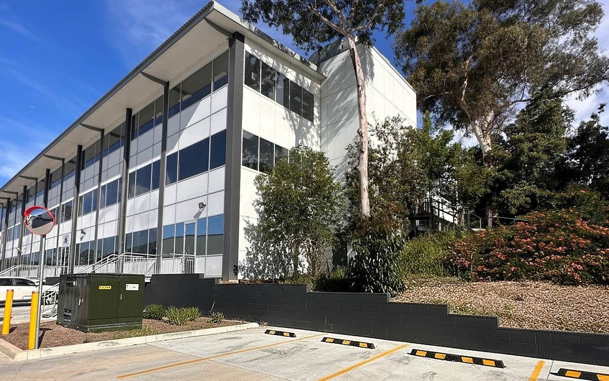 Exterior of the TCann facility at Thornleigh, with trees and parking spaces in front