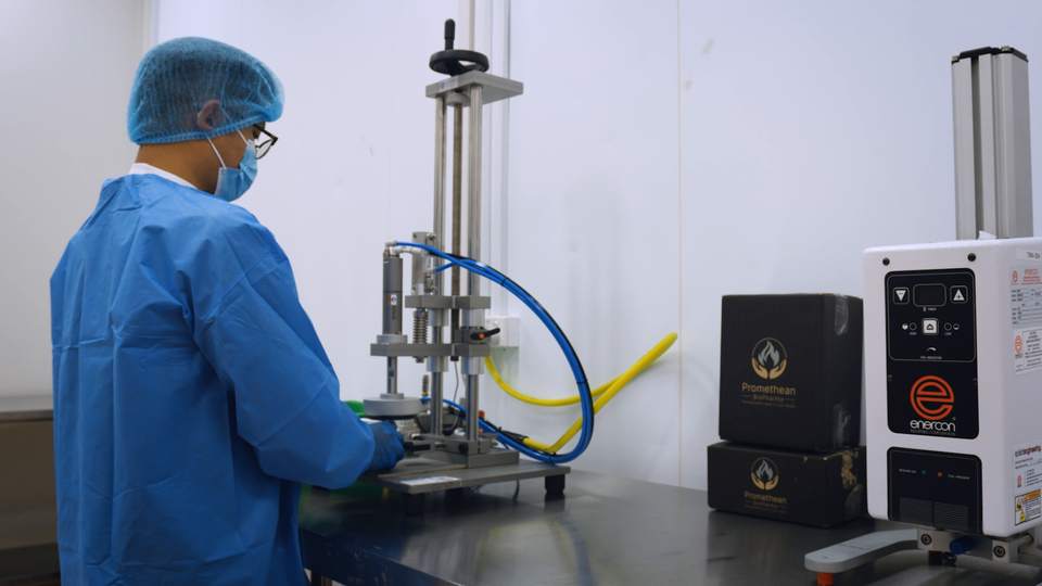 A technician operates packaging equipment in a controlled production area